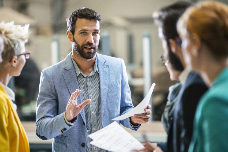 Person explaining a concept to a group of people.