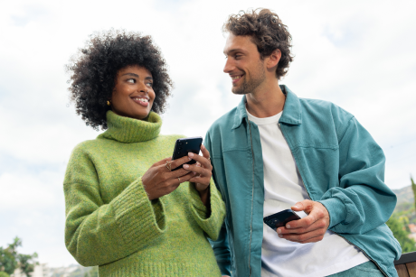 Two people with phones talking.