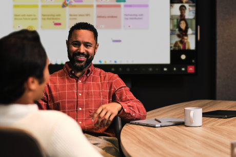 Two people seated at a conference table.