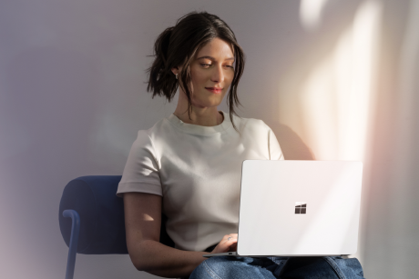 A person seated working on a laptop.