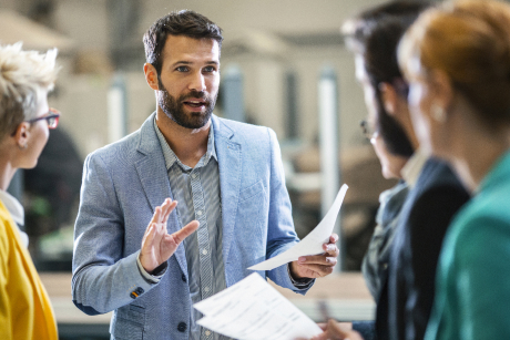 Person explaining a concept to a group of people.