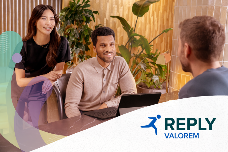 Three people talking at a conference table.