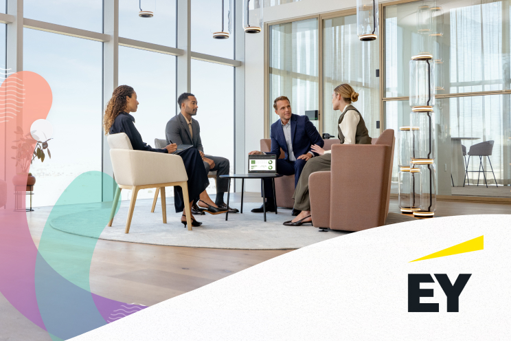 A group of four people having a discussion in an office