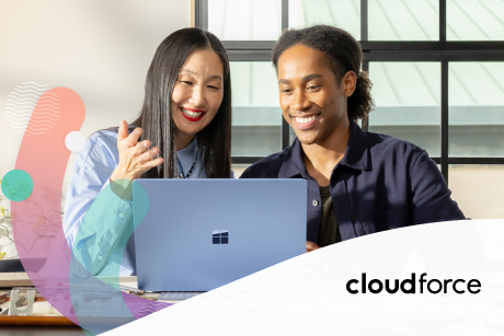 Two people working on a laptop and smiling.