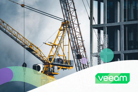 Yellow construction cranes by a building under construction.