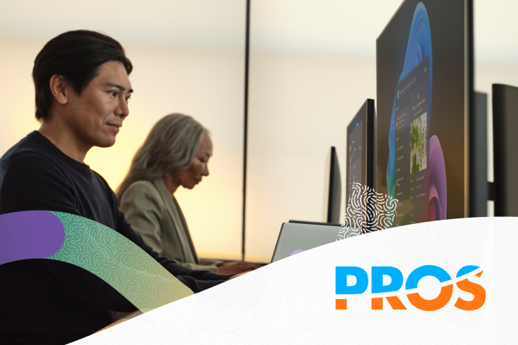 Two people are working at their own desktops.