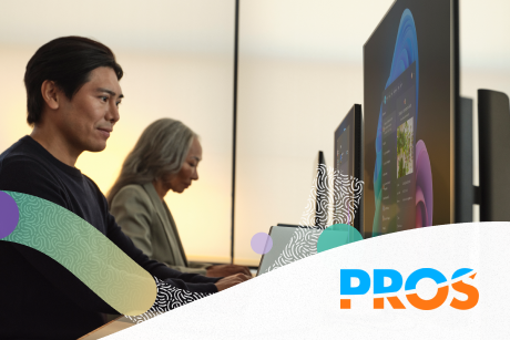 Two people are working at their own desktops.