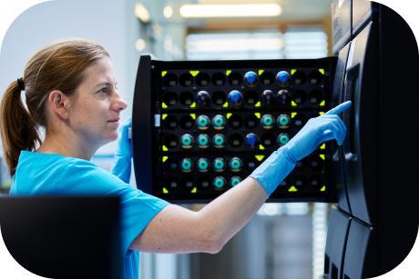 A person examining the contents inside a medical freezer.