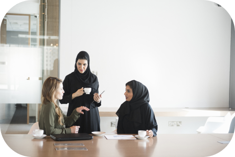 Three colleagues meet around a conference table