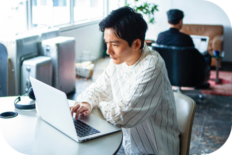 Person seated at a table using a laptop.