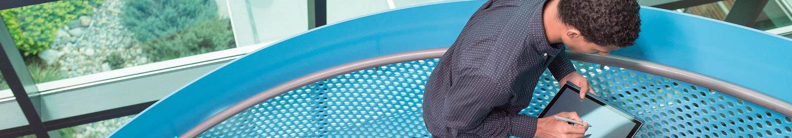 Man walking up stairs and working on Surface