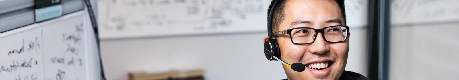 A smiling tech industry employee wearing a headset