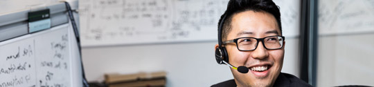 A smiling tech industry employee wearing a headset