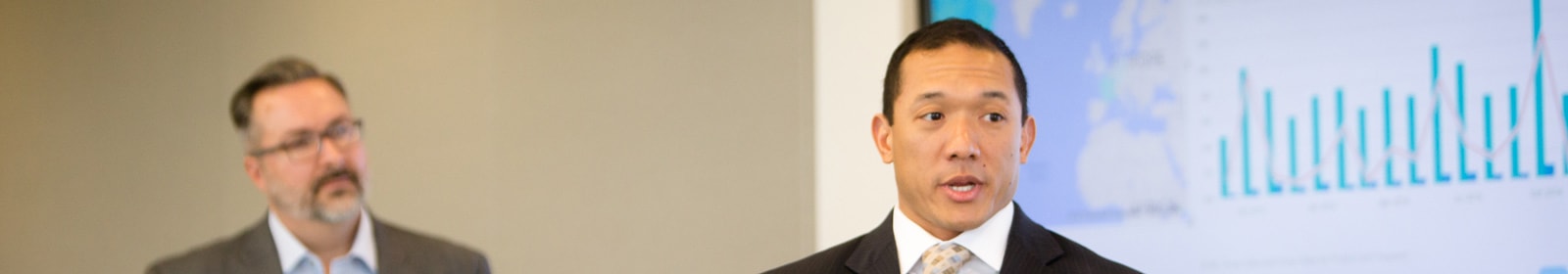 Two men presenting in front of room