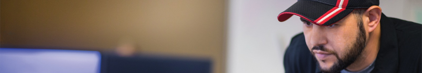 A man watches his co-worker's computer screen