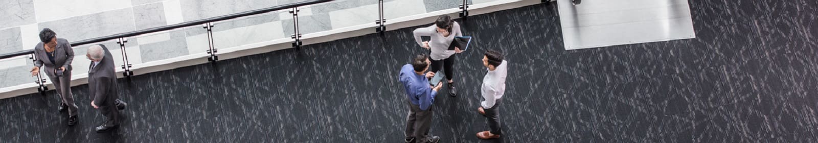 Employees chat on an elevated walkway in an office building