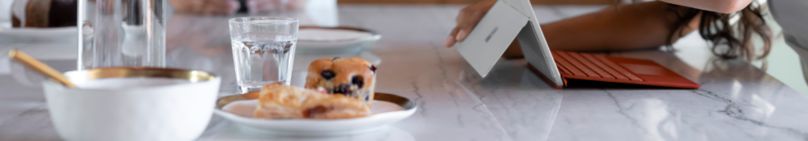 Contextual photograph of female child working Surface Go 3 with adult female looking on