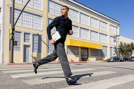 Man holding a Surface Pro and crossing the street