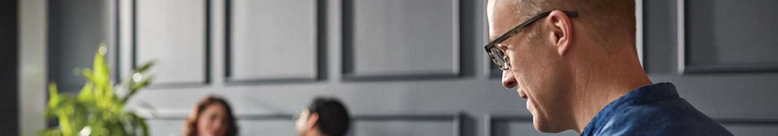 Man in an office wearing glasses and working on a Surface