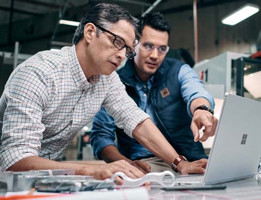 Two men in shop looking at a computer screen