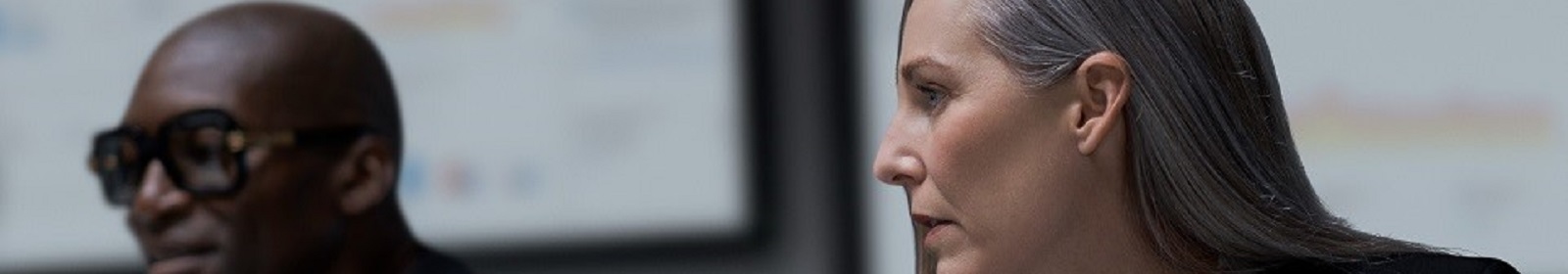 Two tech industry employees looking at a computer screen out of frame