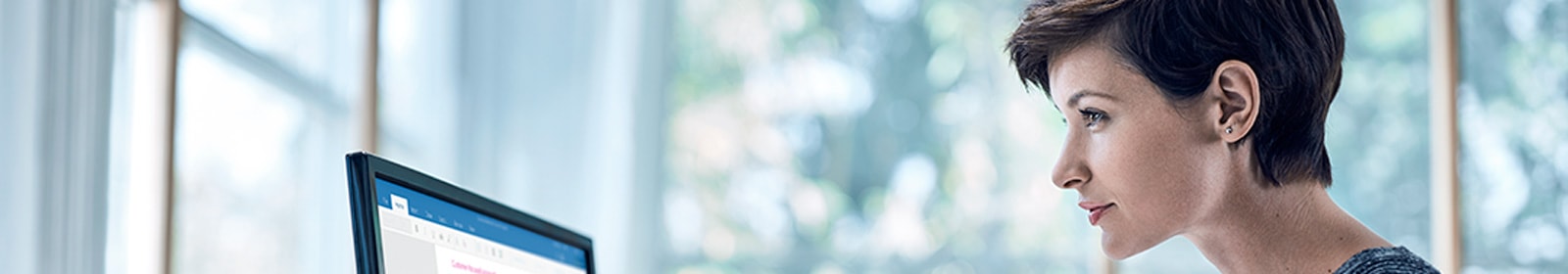 Woman looking thoughtfully at computer monitor