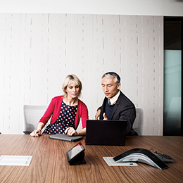 Two coworkers working on laptop having discussion
