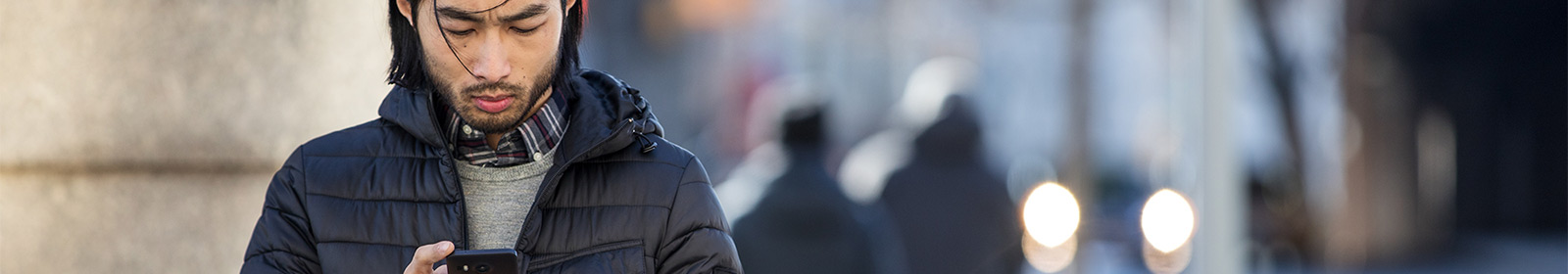 Man standing outside and working on cellular device