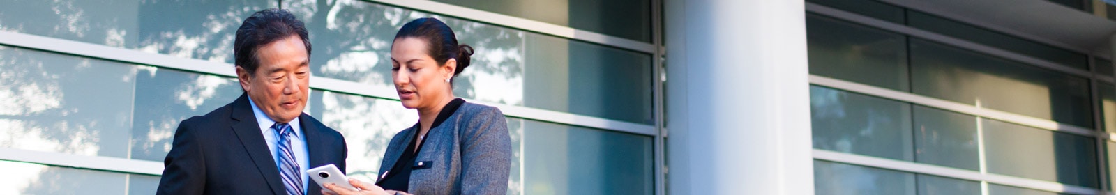 Man and woman looking at phone outside of office