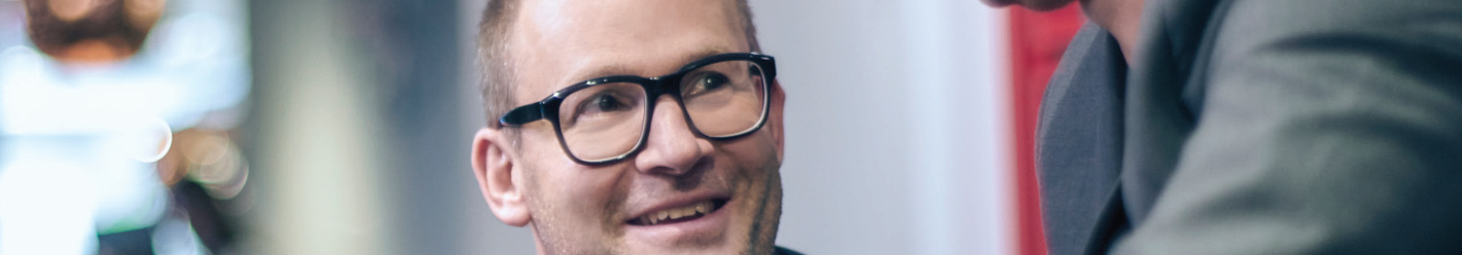 a man smiles while discussing business