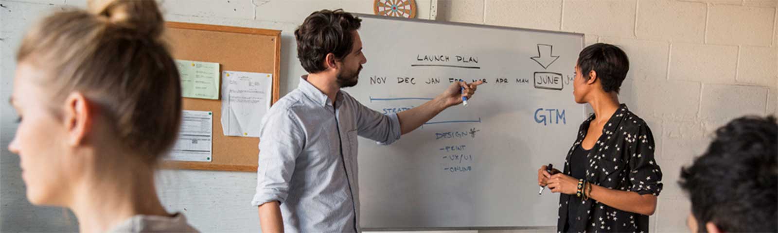 Two people working at a white board