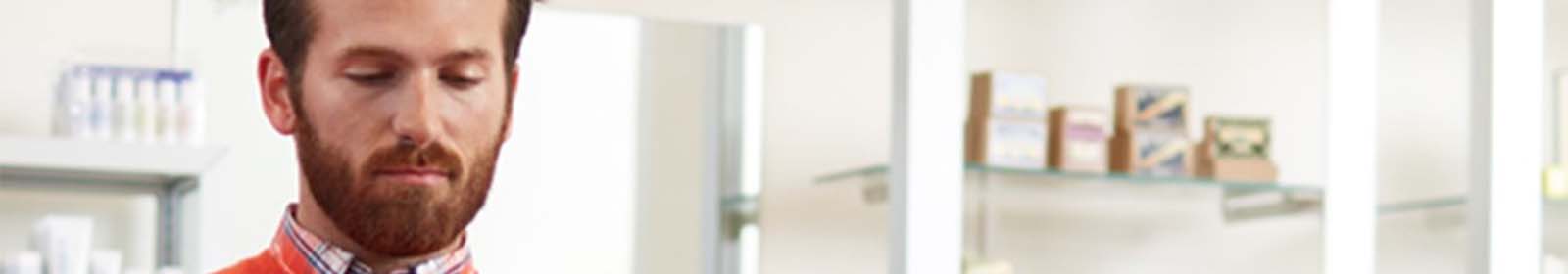 Man in orange sweater processing a charge card 