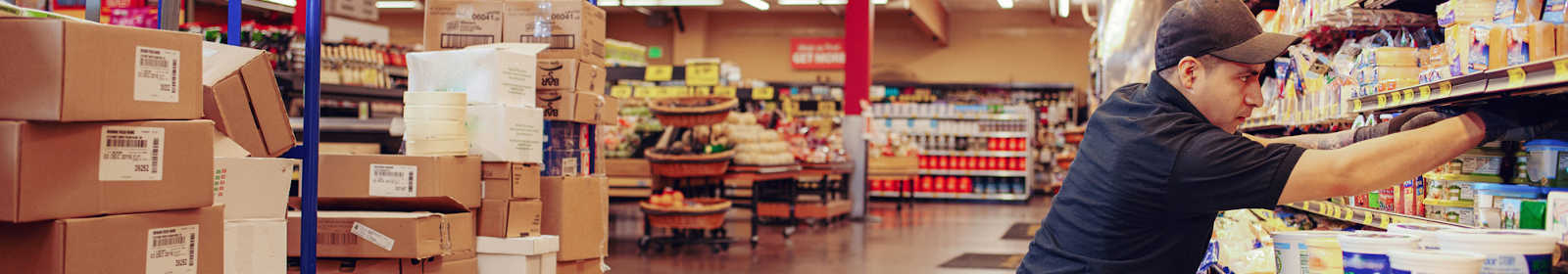 Worker stocking a grocery shelf