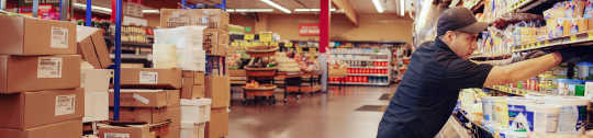 Worker stocking a grocery shelf