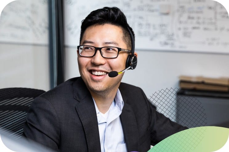 A person sitting at a desk wearing a headset