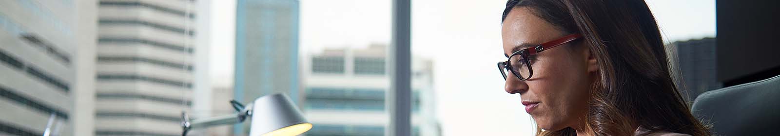 A seated woman looks at a laptop screen