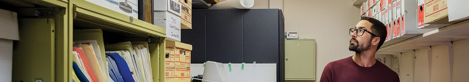 A man looks for files in an office storage room