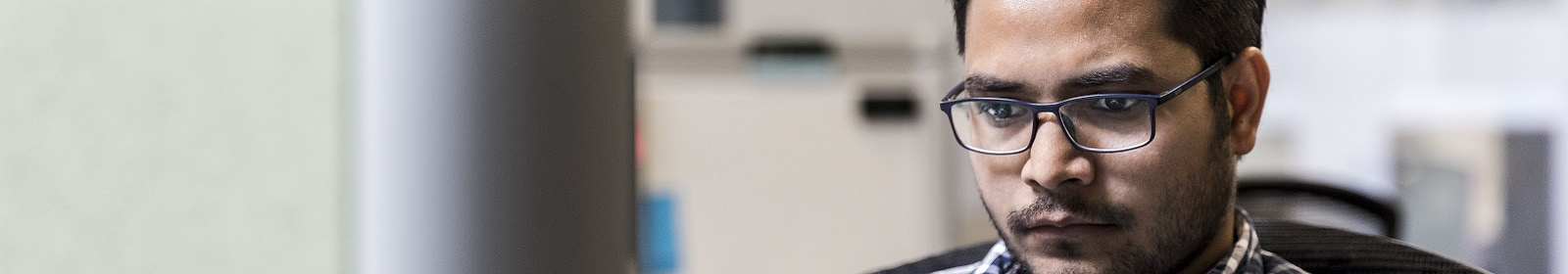 An office worker in his cubicle analyzes a problem