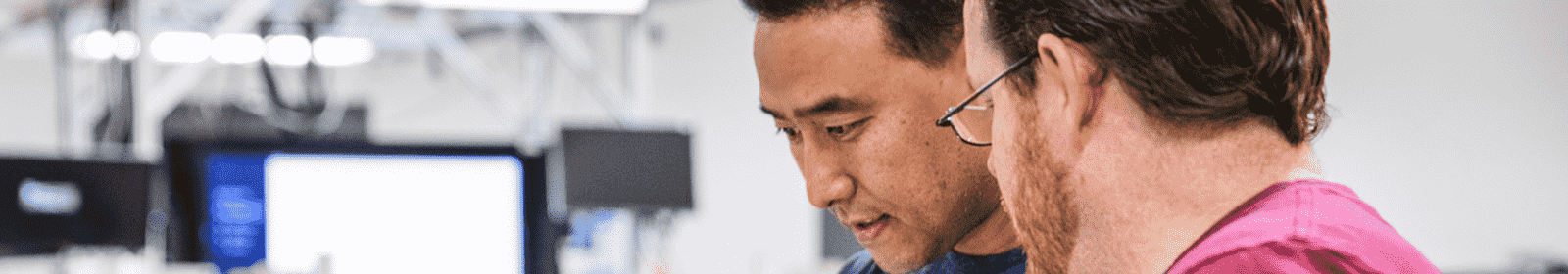 Two male colleagues collaborating with open laptops