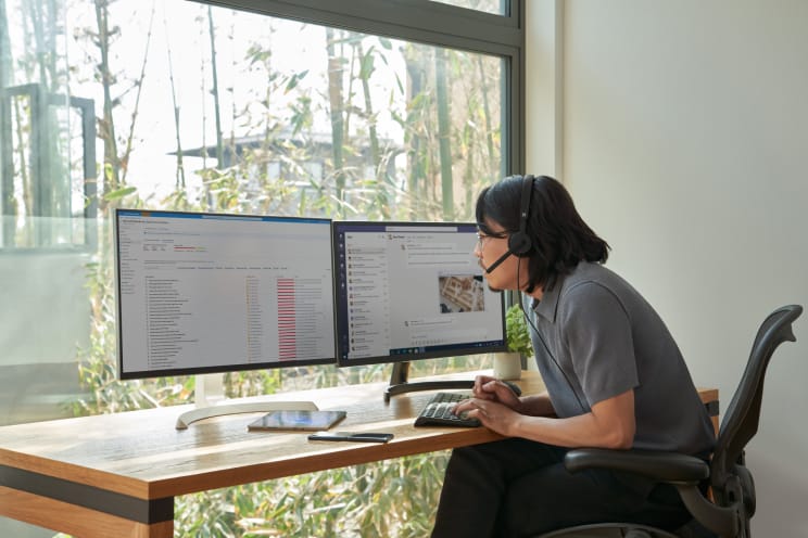 A person wearing a headset working at a computer