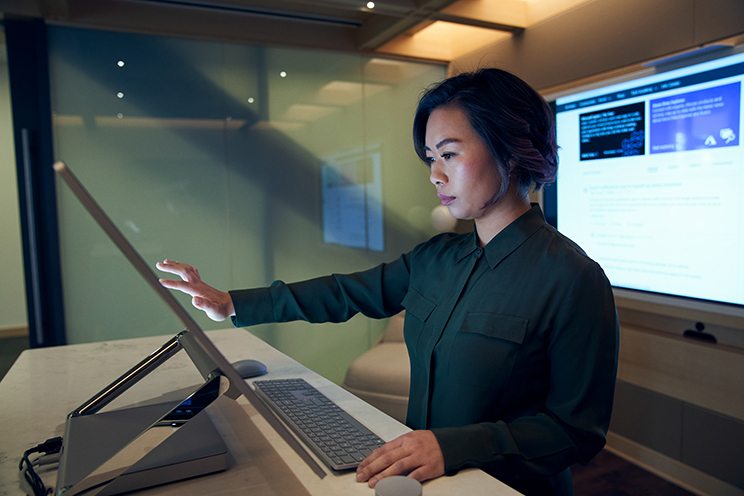 Woman using computer to examine security details in office environment