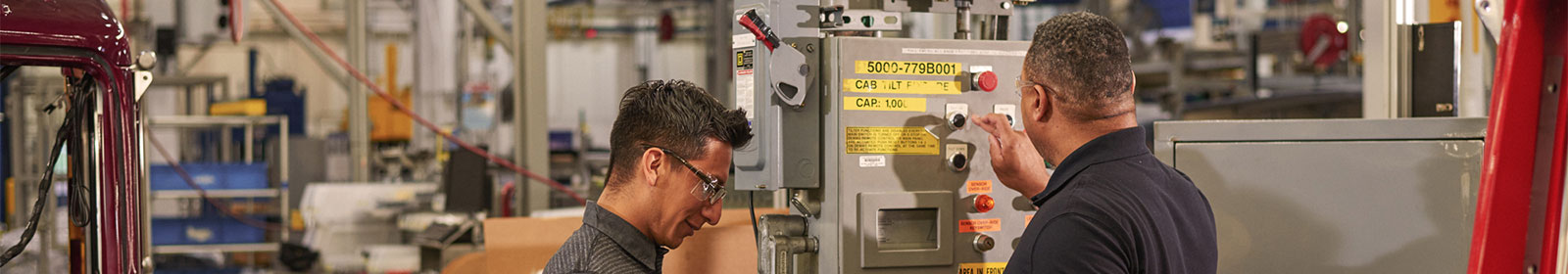 Two men working in a manufacturing plant using Surface tablet