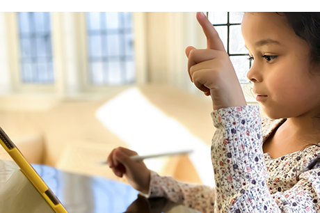 Young girl participates in an online class with a digital tablet
