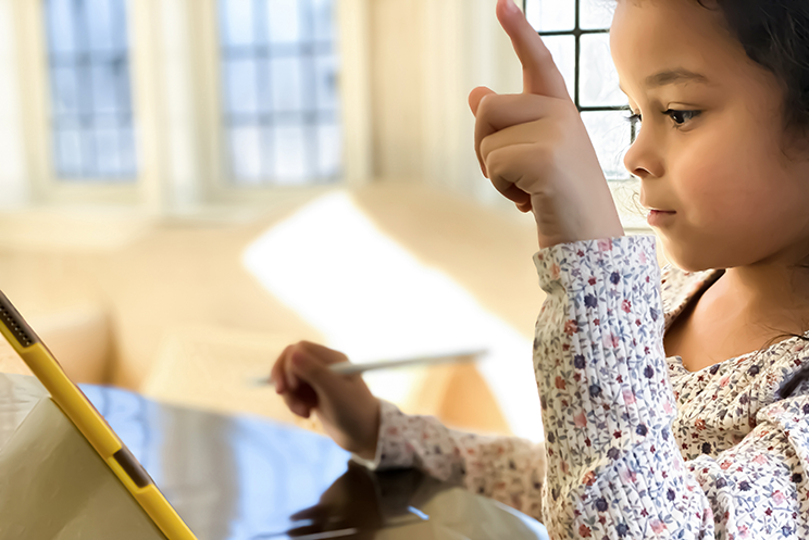 Young girl participates in an online class with a digital tablet