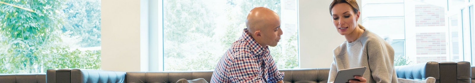 Two colleagues work together on a tablet