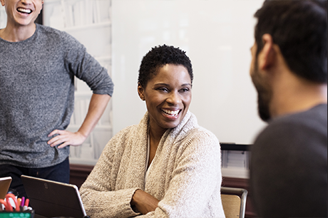 A person smiling while interacting with two other people