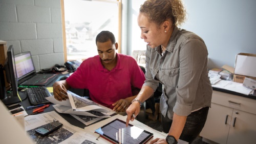 Two employees reviewing documents at desk