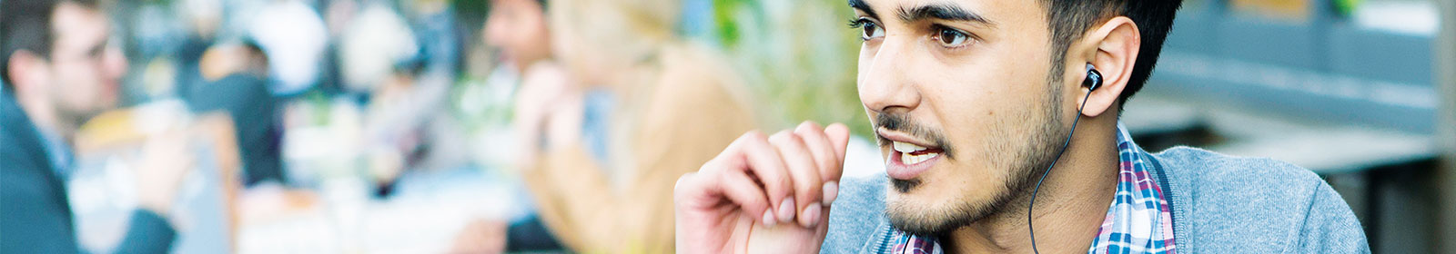 Man wearing earbuds sitting outside