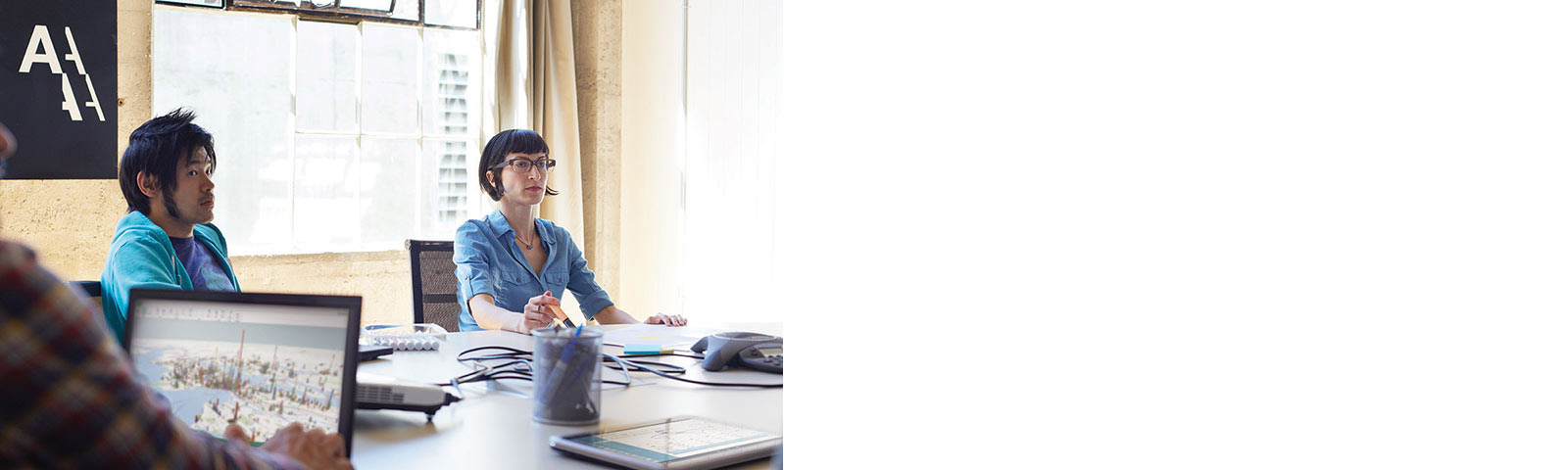 3 coworkers at table listening in during meeting