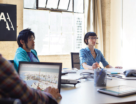 3 coworkers at table listening in during meeting